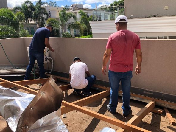 Foto de egressos trabalhando no telhado da casa de Chico e Rosa. Foto: PMPR/Divulgação