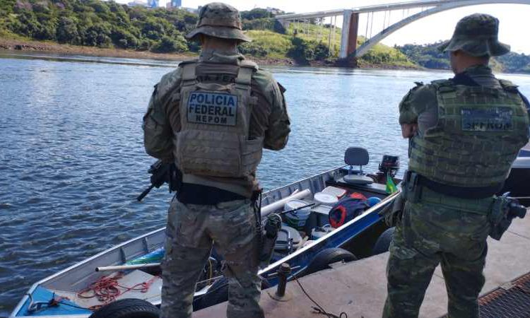 Embarcação resgatada, com a Ponte da Amizade ao fundo. Fotos: PF/Divulgação