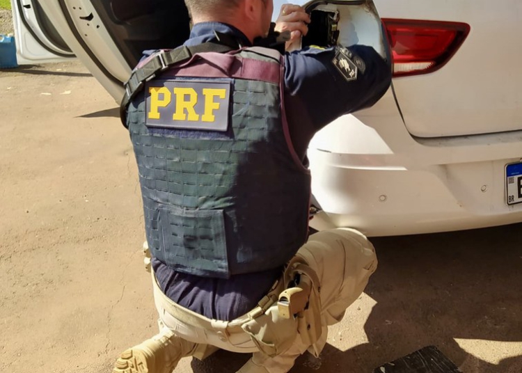 Cocaína sendo retirado veículo pela lanterna traseira quebrada. Foto: divulgação/PRF