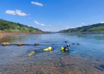 Com a Ponte da Integração ao fundo, mergulhadores inspecionam tubulações no Rio Paraná. Foto: Sanepar